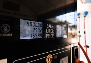 A gas pump with a updated sale price on it that has increased by 1.5 cents from 2023.