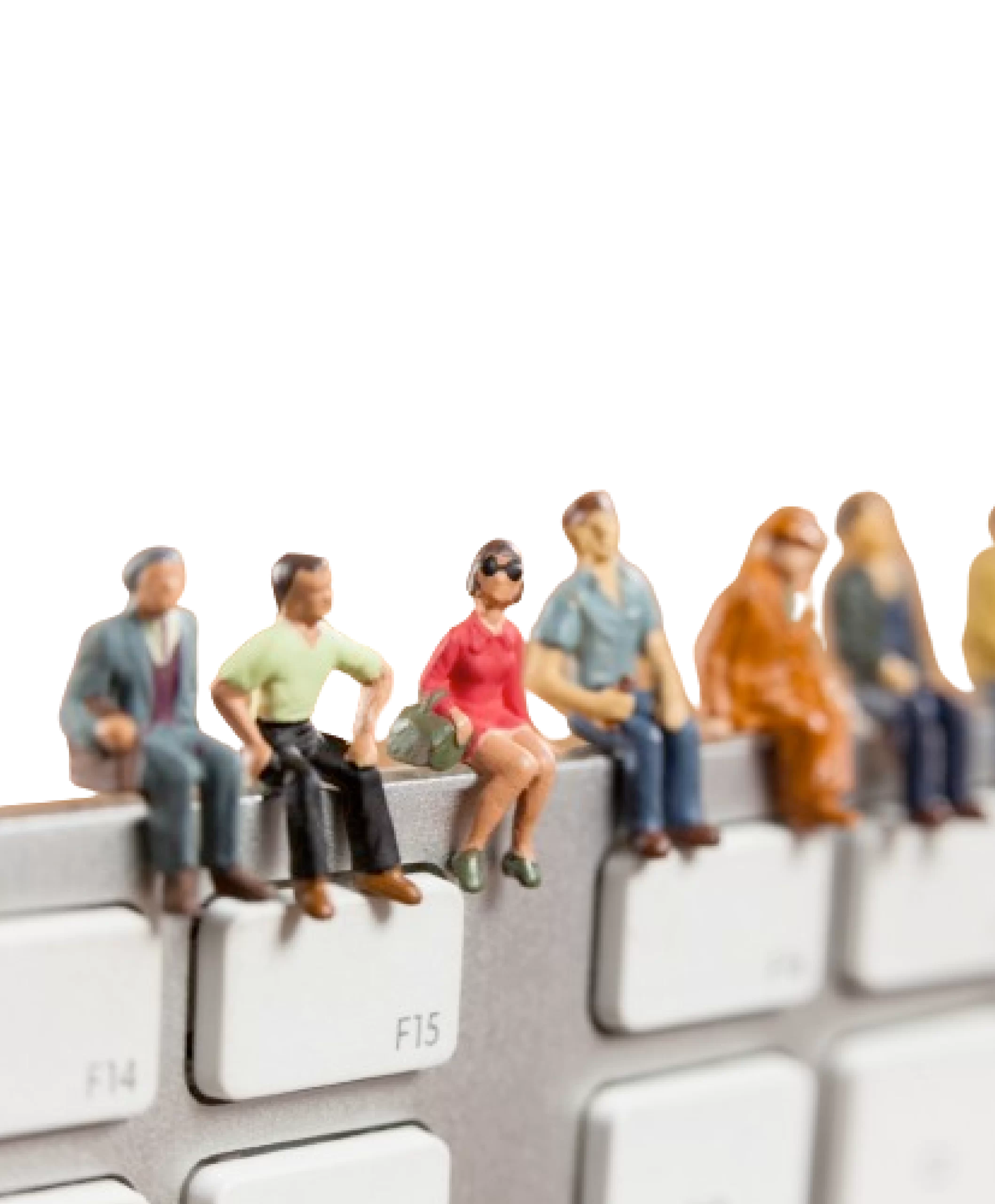 Miniature people sitting on a keyboard.